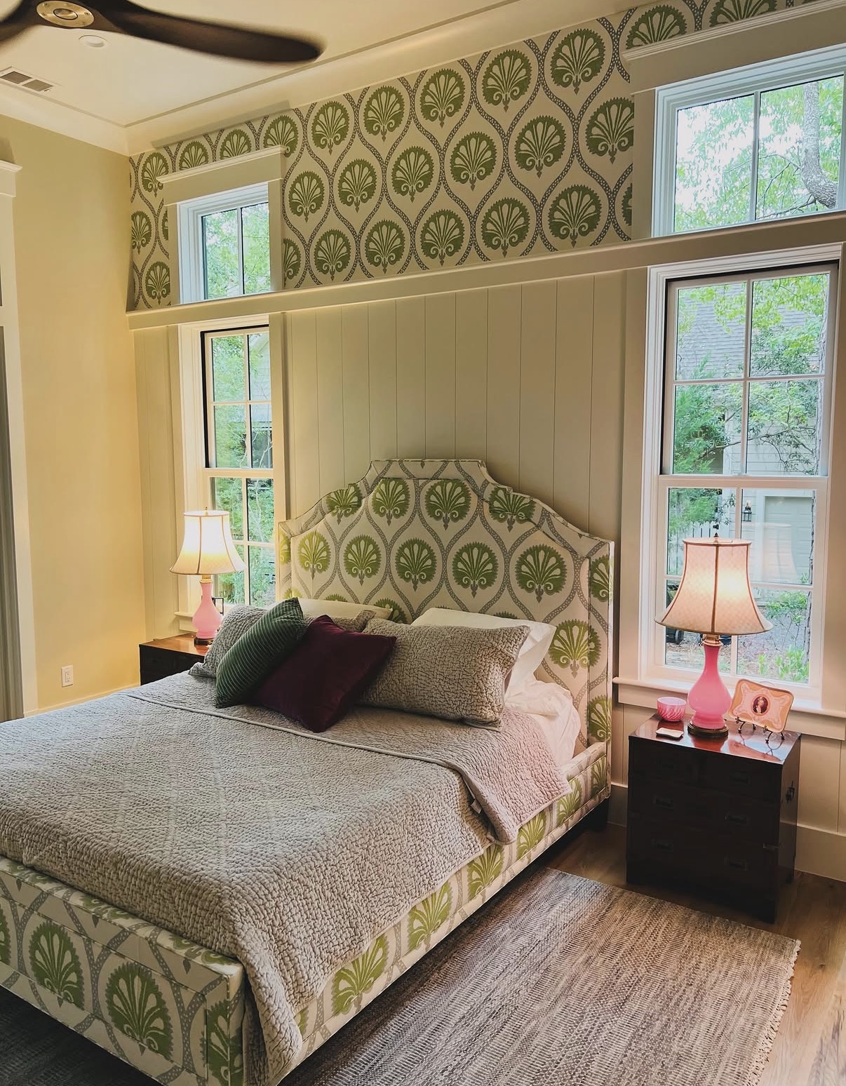 Green shell medallion wallpaper and matching upholstered headboard in a Lowcountry bedroom