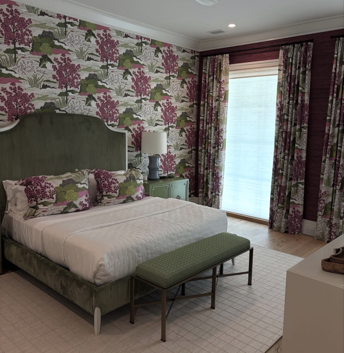 Magenta and green Japanese treescape wallpaper with coordinating drapery in a bedroom