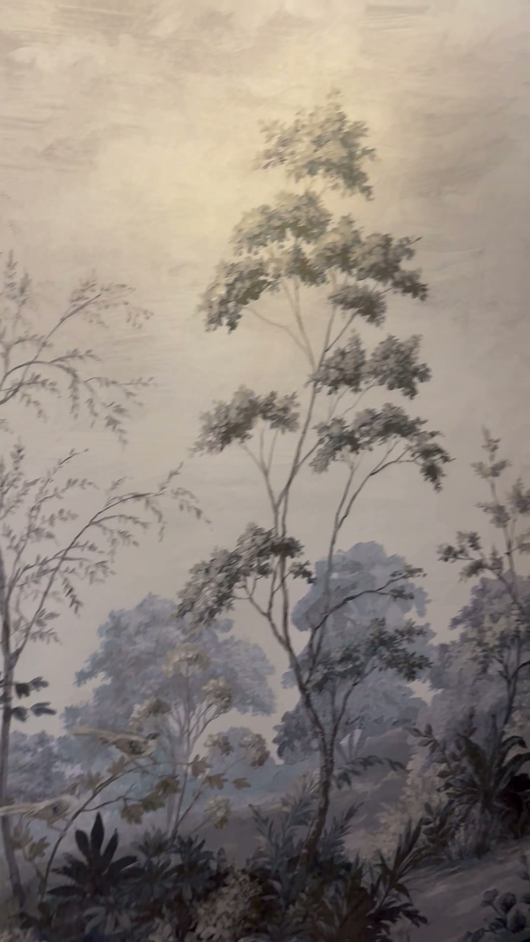 Painterly detail of the moody landscape mural — silhouetted trees in soft mist