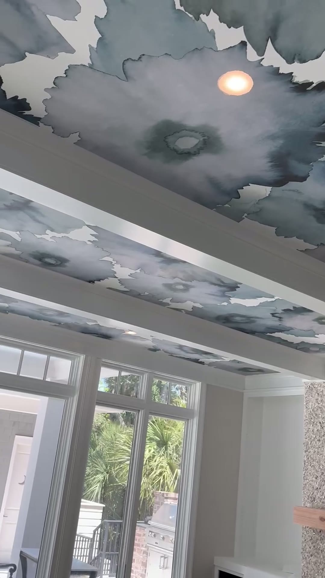 Watercolor ceiling mural framing French doors with a marshfront view