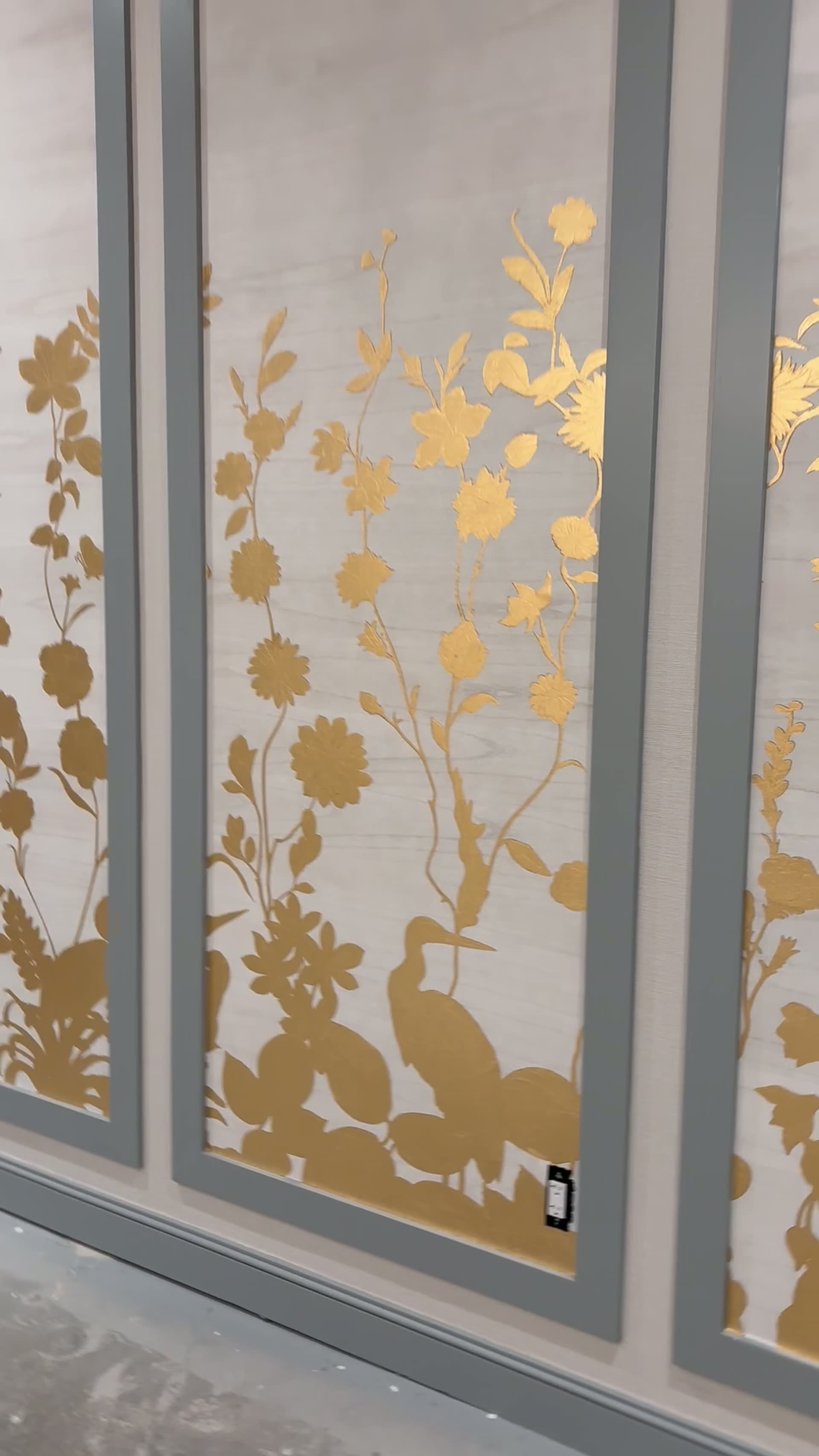 Hand-painted gold heron detail within a garden mural panel