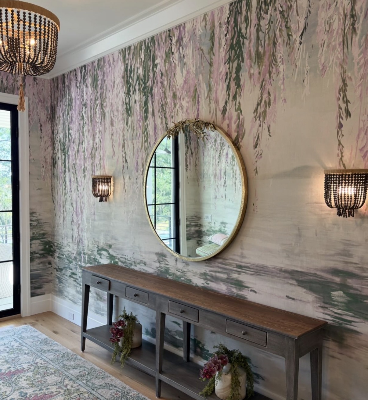 Lavender-and-green weeping willow mural wrapping an entry with round gilt mirror and beaded chandelier